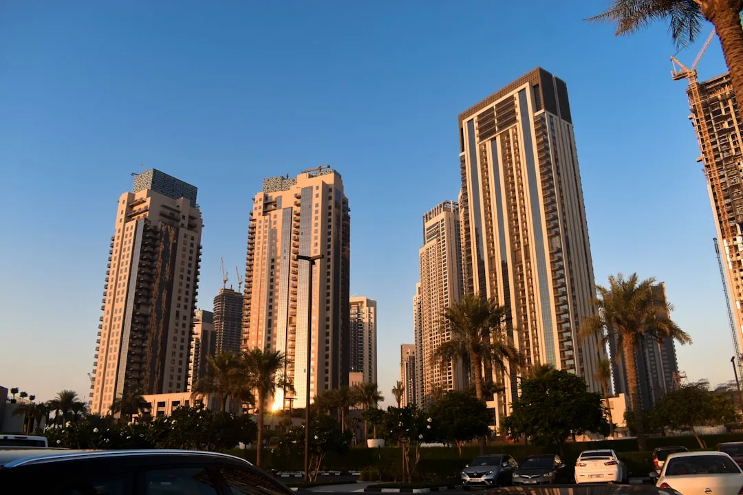 Al Barsha v Dubaji: Dostupná Čtvrť u Mall of the Emirates Obytné věže v Al Barshe za soumraku s palmami a zaparkovanými auty