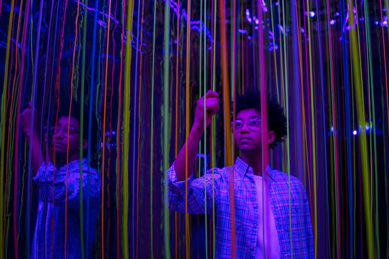Museum of Illusions Dubai: Iluze a Optické Klamy v Al Seef Návštěvníci procházejí interaktivní instalací s barevnými neonovými strunami a zrcadly
