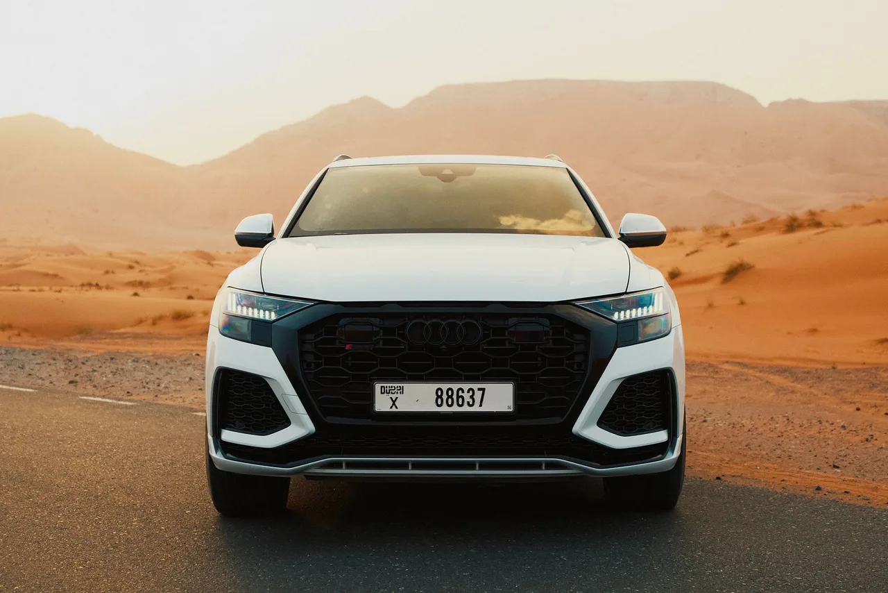 Půjčené SUV na poušní silnici v okolí Dubaje při západu slunce