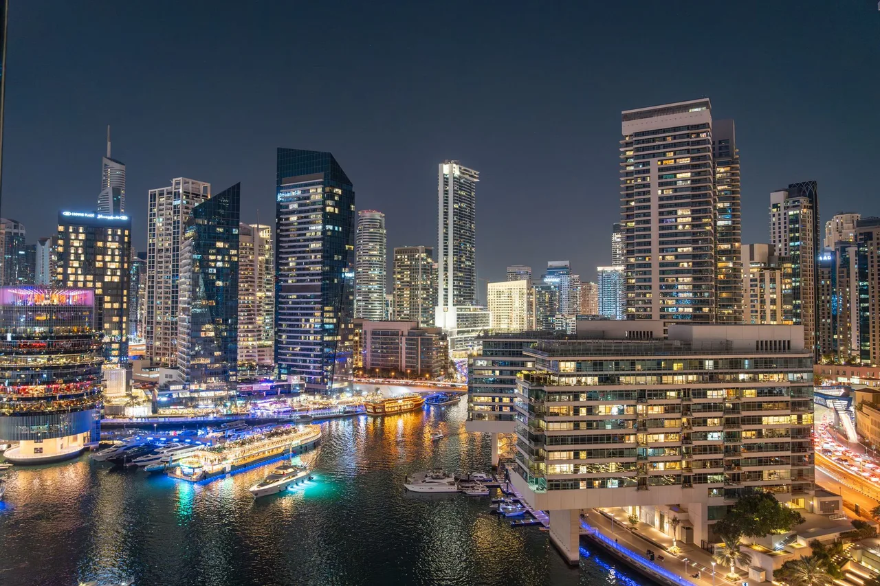 Noční panorama Dubai Marina s rozsvícenými mrakodrapy a odrazem ve vodě